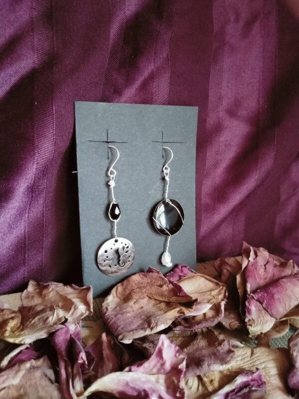 Une paire de boucle d'oreilles dépareillée avec sequin et perle goutte