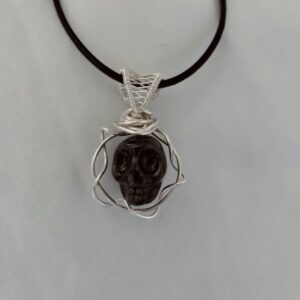 Pendentif crâne dans sa couronne avec sa bellière tissée