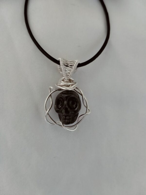 Pendentif crâne dans sa couronne avec sa bellière tissée