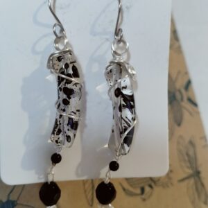 Paire de boucles d'oreilles avec leurs perles incurvées transparentes et la perle de verre