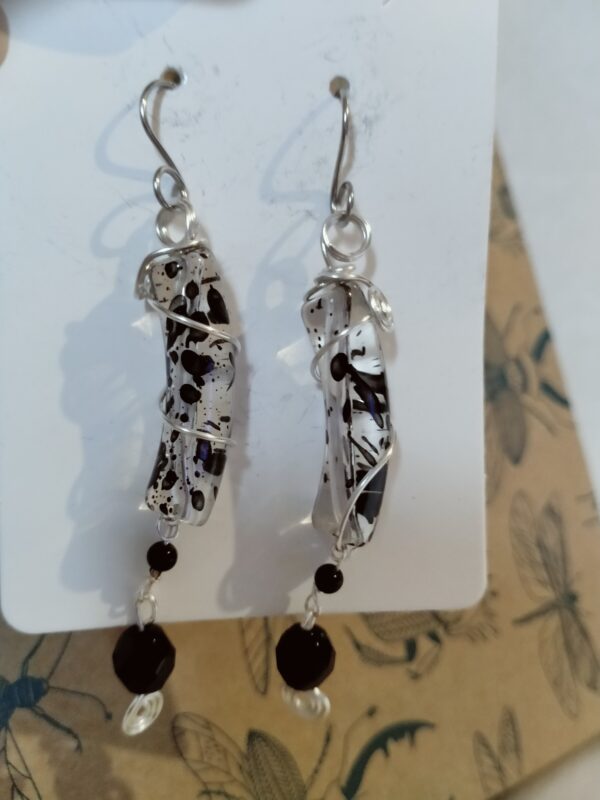 Paire de boucles d'oreilles avec leurs perles incurvées transparentes et la perle de verre