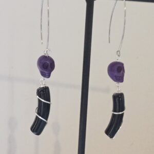 Paire de boucles d'oreilles minimalistes avec leurs perles incurvées noires et leurs skull en Howlite
