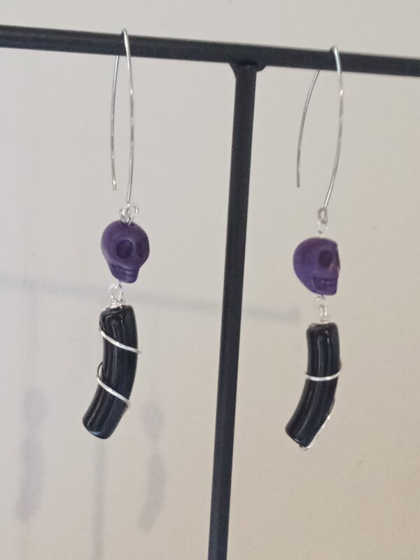 Paire de boucles d'oreilles minimalistes avec leurs perles incurvées noires et leurs skull en Howlite