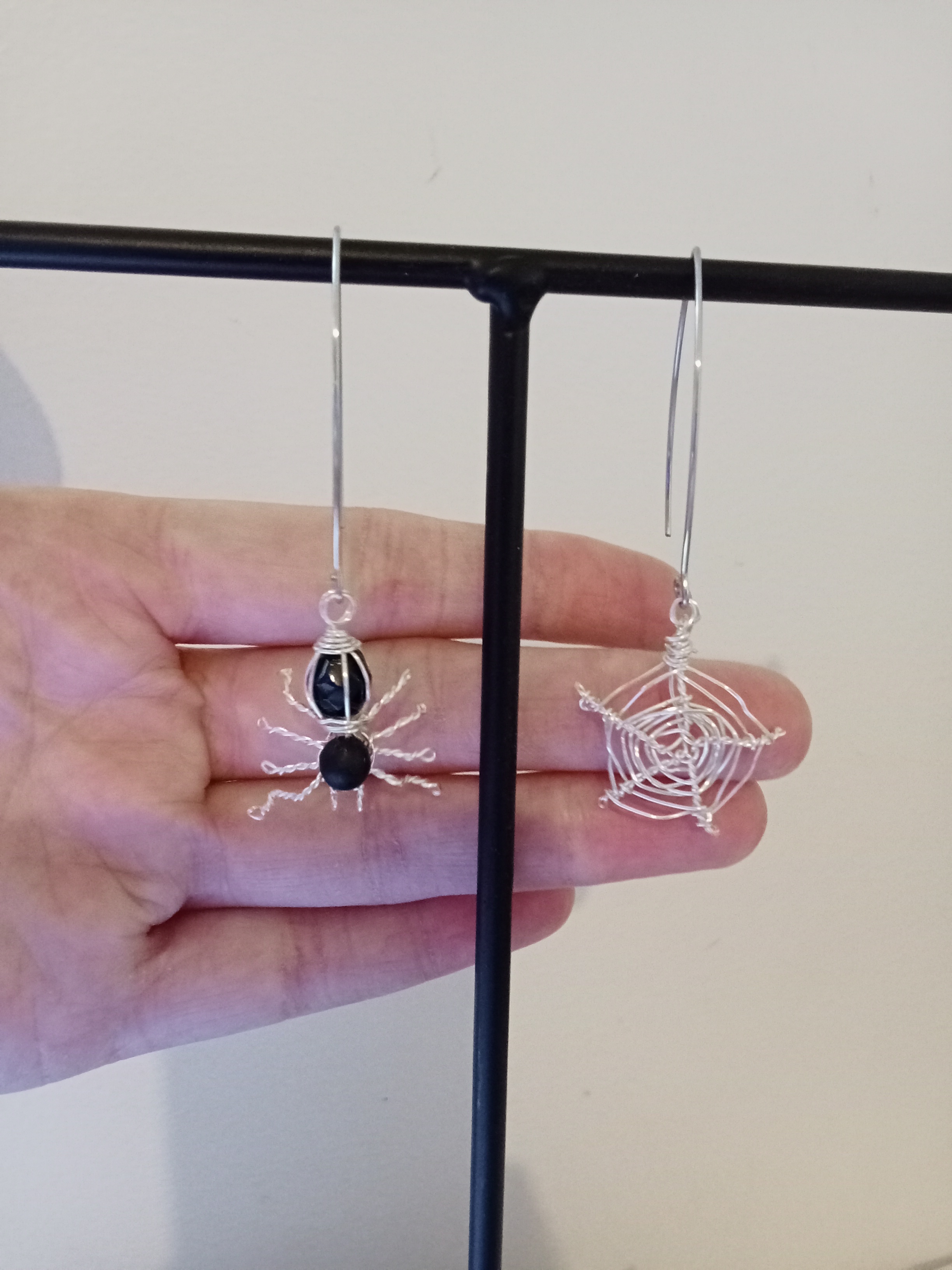 Paire de boucles d'oreilles dépareillée avec son araignée de perles en verre et sa toile